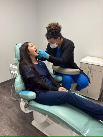 Student practicing chairside assisting with a patient at the Longview campus