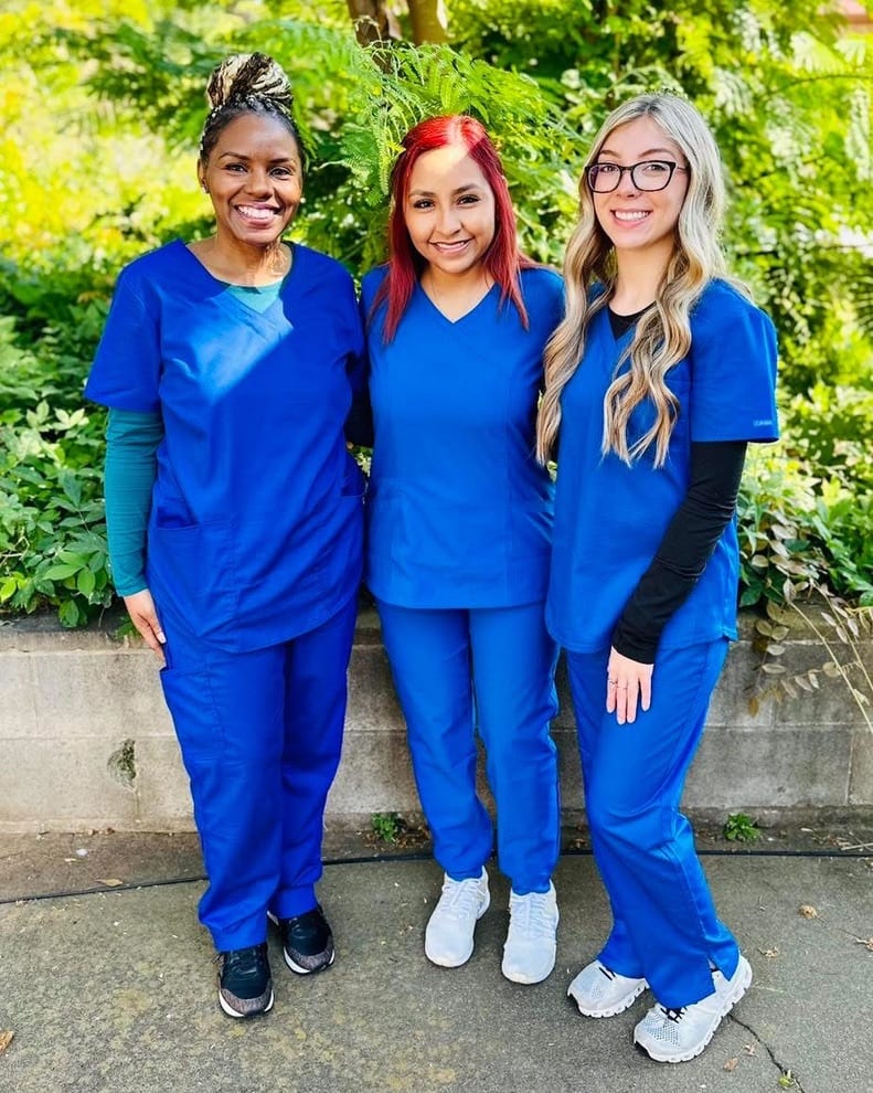 Three Premier Dental Academy students in scrubs
